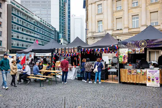 Die Reihe der Food-Stände am Samstagvormittag, die ersten Gäste sitzen an den Bänken