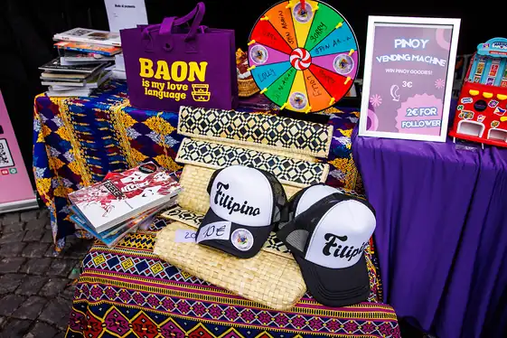Merch-Tisch mit BAON-Tasche, Filipino-Caps und Glücksrad