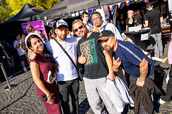 Freunde mit Daumen hoch zwischen den Ständen