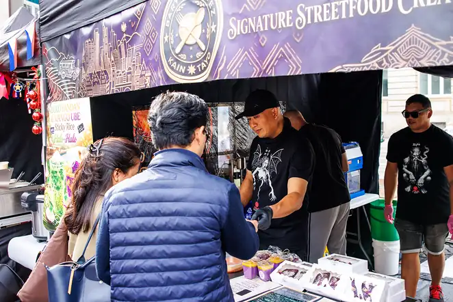 Verkauf am Streetfood-Stand, auf dem Tresen stehen Ube-Desserts