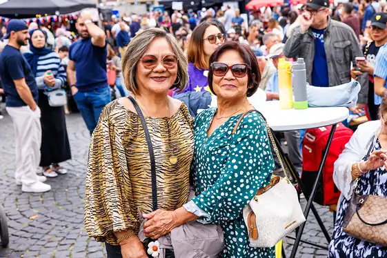 Zwei Besucherinnen im Festtagsoutfit mitten im Gedränge