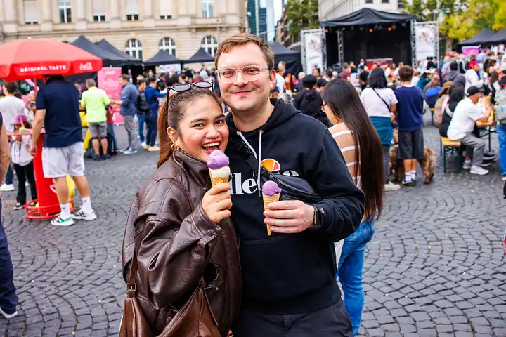 Besucherpaar mit lila Ube-Eis vor der Bühne