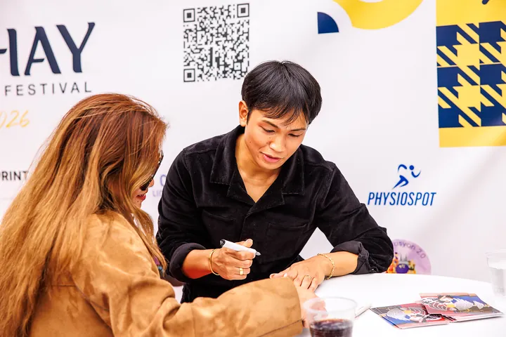 Meet and Greet: ein Gast schreibt ein Autogramm