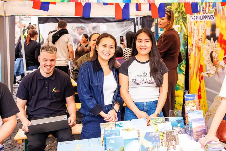 Team am Tourismus-Stand mit Broschüren über die Philippinen