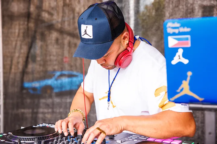 DJ mit roten Kopfhörern am Pult