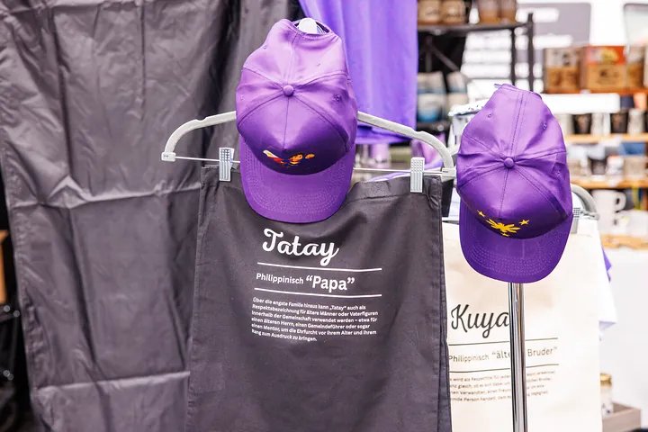 Merch mit Tatay- und Kuya-Taschen und lila Caps