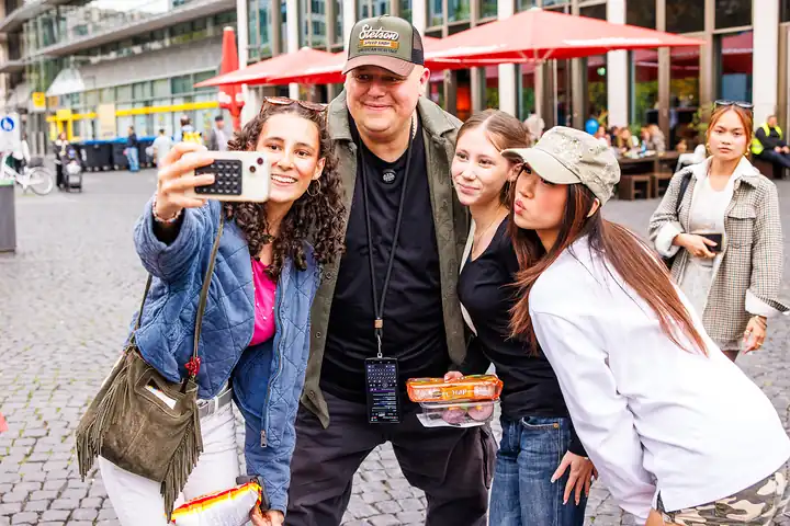 Food-Vlogger Bernd Zehner macht ein Selfie mit drei Besucherinnen